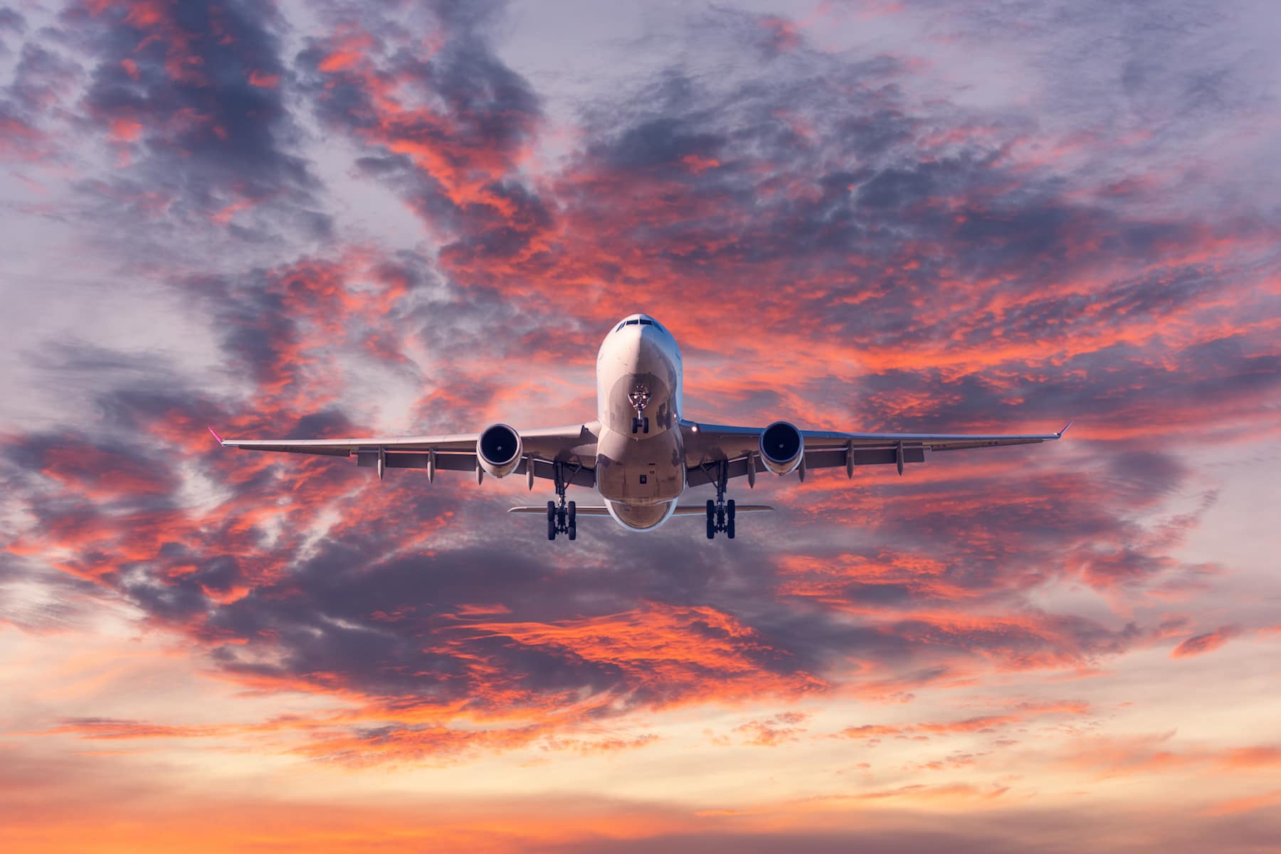 landing-passenger-airplane-at-colorful-sunset-MRSHV6Q